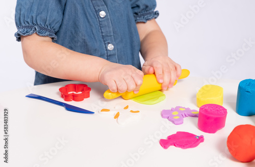 Beautiful girl plays and rolls plasticine