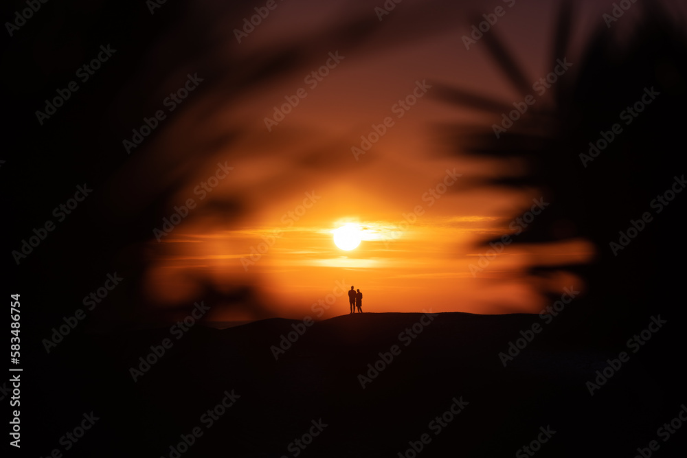 Silhouette of a couple on a tropical beach at sunset