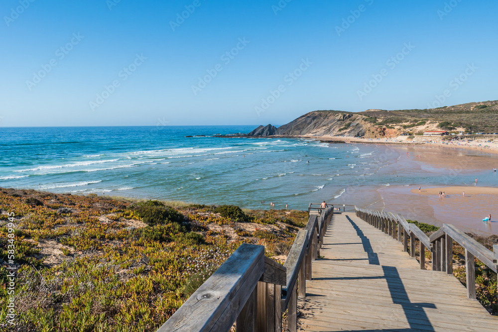 Viewpoint on blurred wooden pathway to sea and sand of Amoreira beach, Aljezur PORTUGAL