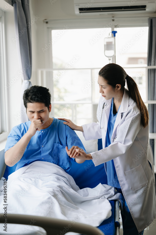 Fototapeta premium Doctor and young male patient who lie on the bed while checking pulse, consult and explain with nurse taking note in hospital