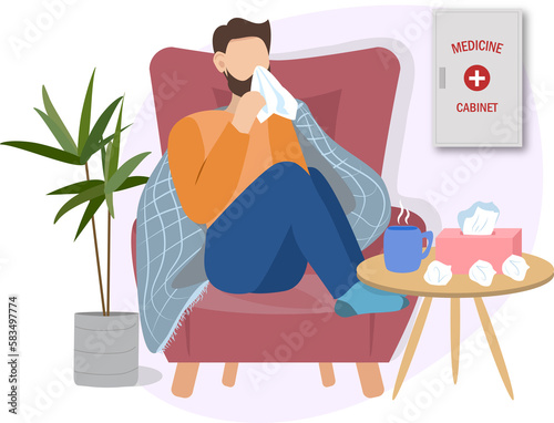 sick man possibly with cold or flu is at home on a sofa having a cup of tea or hot drink