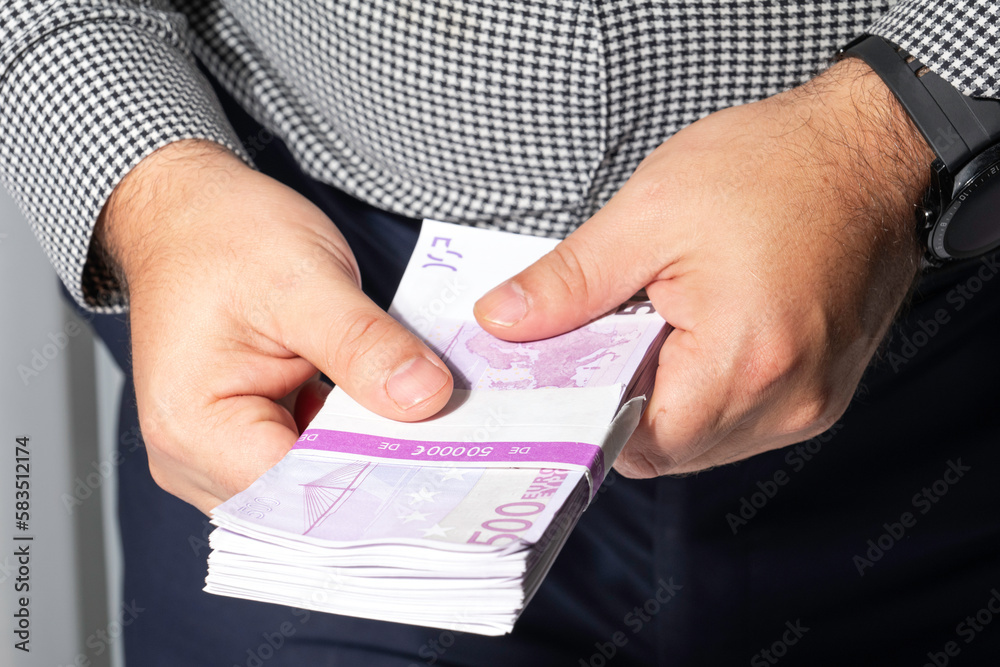 Successful businessman counting a lot of euro money cash notes