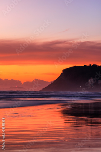 Burleigh beach sunrise with colourful clouds over Burleigh Headland. Gold Coast, Australia © Bostock