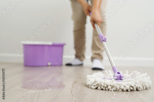 Employees use mop cloths to clean the floor inside the house.