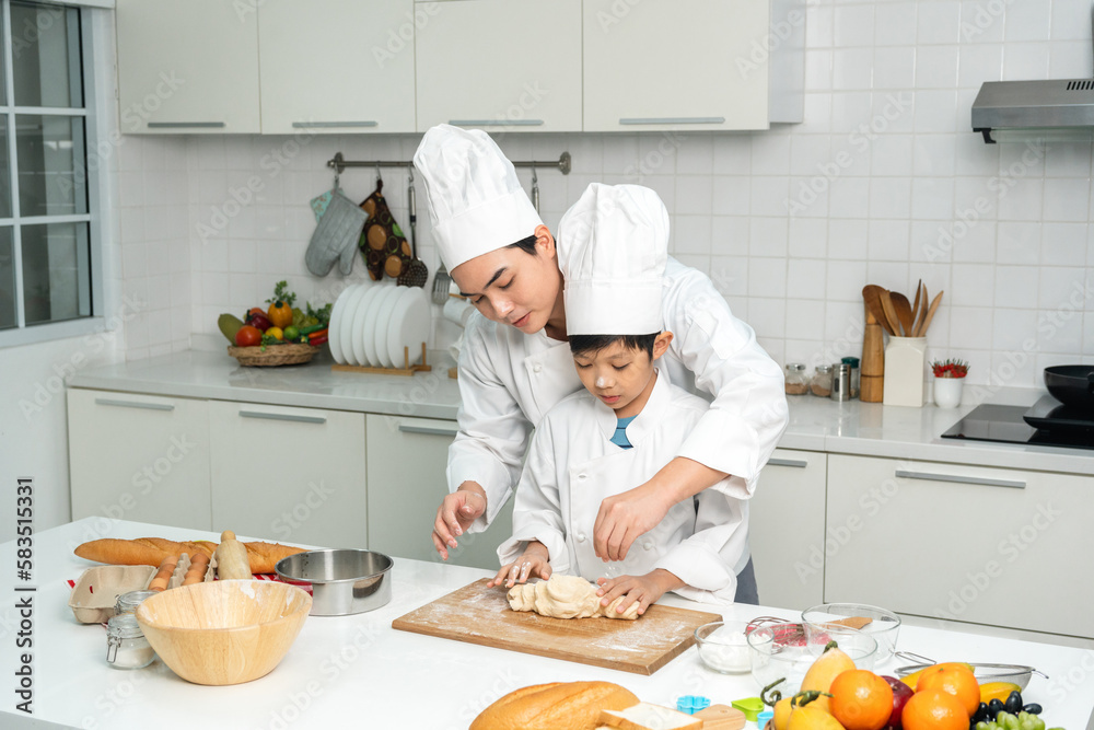 Young handsome asian man chef cooking breakfast in the kitchen. Happy asian man preparing food with ingredient. Chef in uniform in the kitchen.