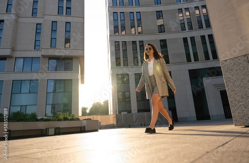 Business woman walking drinking coffee. Lawyer professional or similar walking outdoors happy holding paper cup © opolja