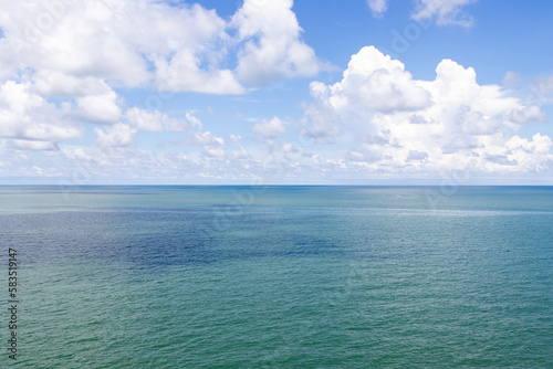 Beautiful calm turquoise color sea and blue sky with white color cloud background