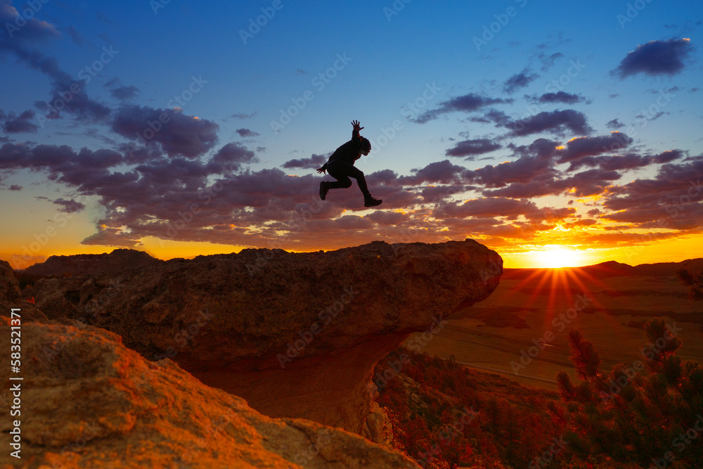Man Leaping On Ridge At Colorful Sunset