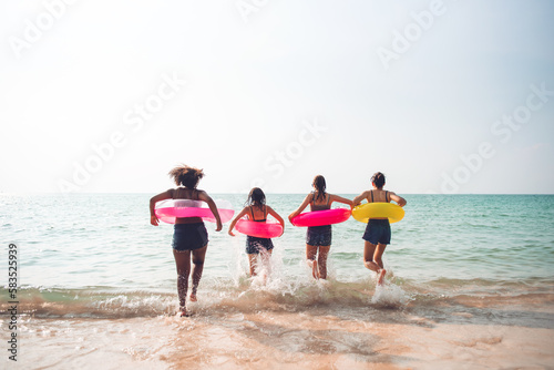 Group of teenager friends having fun with swim ring on the beach, Young girl enjoying with outdoor activity, Lifestyles on holiday concept.