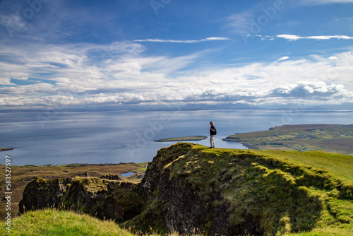 A men on the edge of a trail in The Quiraing