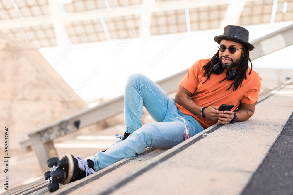 Fototapeta premium Black man enjoy outside. Modern man posing with roller skates..