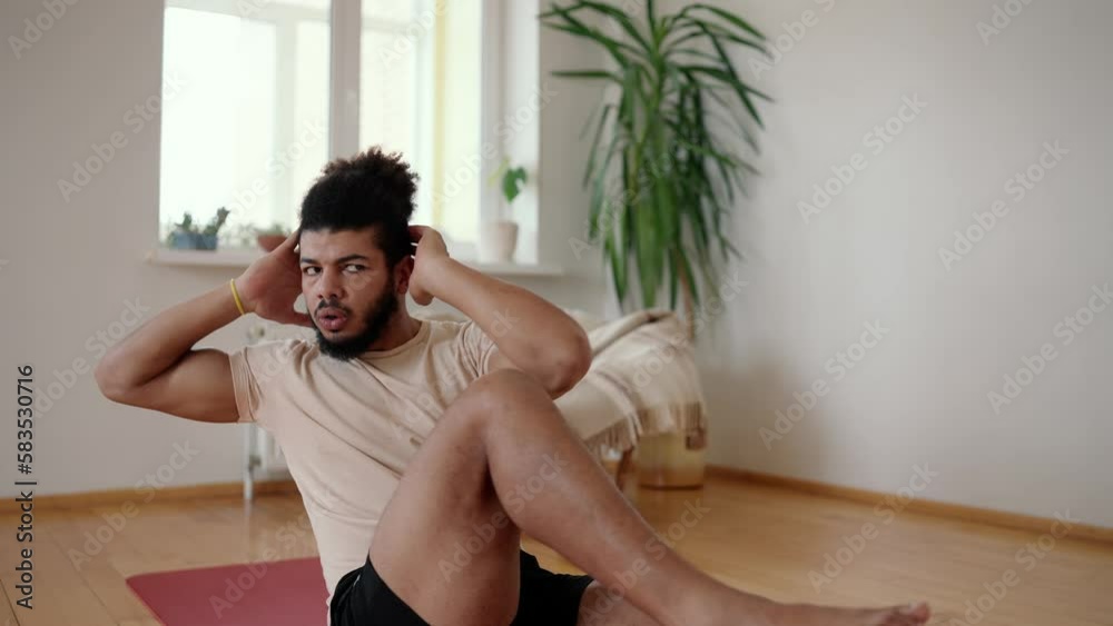 Mixed race guy making cross sit ups exercises for the abs