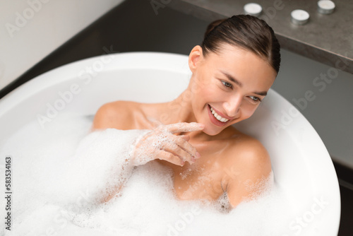Woman Bathing Lying In Water With Foam Relaxing In Bathroom