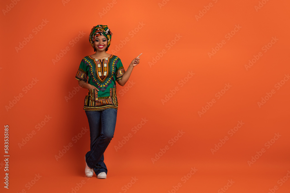 Beautiful african lady in traditional costume showing free space Beautiful african lady in traditional costume showing free space