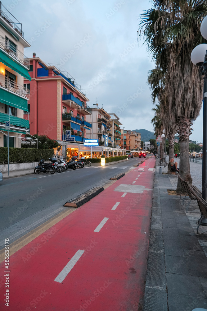 July 2021 Sestri Levante, Italy: Bike lane and a street in the city of the city across the palms and the coastline