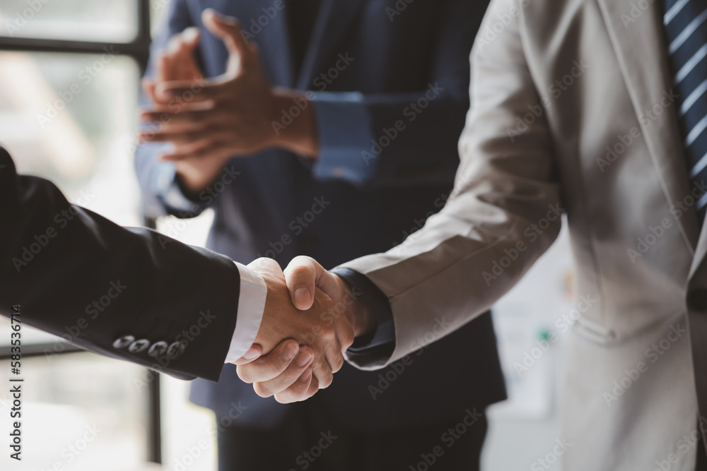 Fototapeta premium Close-up two business men holding hands, Two businessmen are agreeing on business together and shaking hands after a successful negotiation. Handshaking is a Western greeting or congratulation.