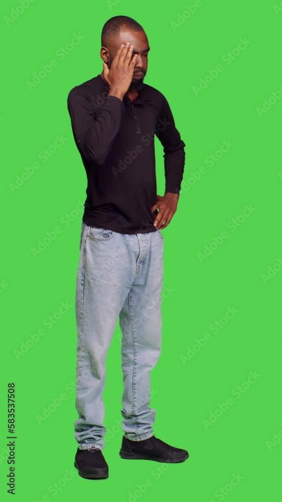 Vertical video: Side view of male model dealing with painful migraine on camera feeling sick, unhappy adult suffering from headache and being ill. Young adult being hurt over full body green screen Vertical video: Side view of male model dealing with painful migraine on camera feeling sick, unhappy adult suffering from headache and being ill. Young adult being hurt over full body green screen