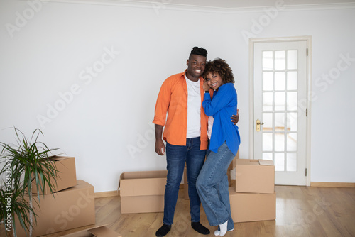Happy Black Couple Posing In Their New Home On Moving Day