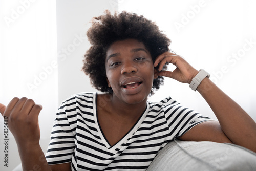 Relaxing black woman talking to camera. African American young woman having conversation.