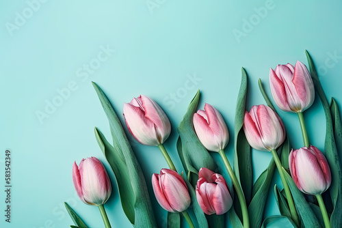 Beautiful composition of spring flowers. Bouquet of pink tulips flowers on a pastel blue background. Flat lay, top view, copy space. 