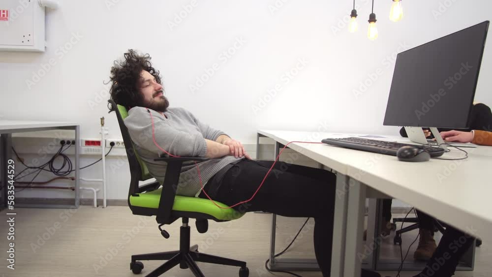 Tired developer relaxing sleeping on chair in startup coworking office
