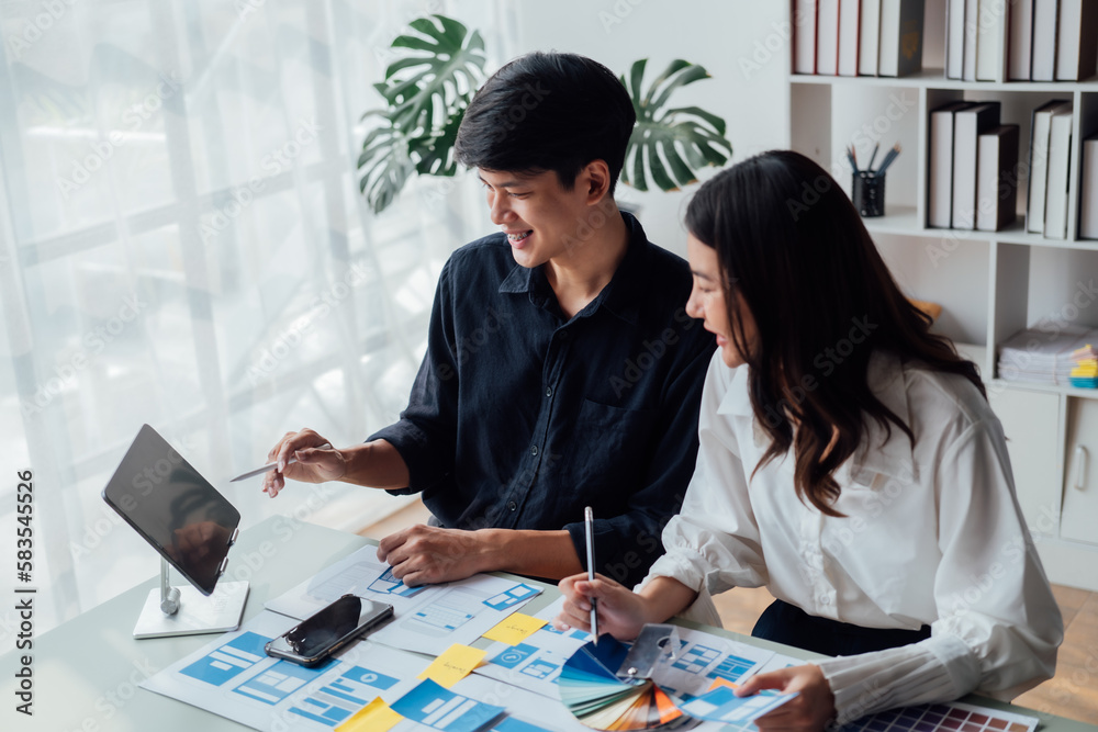 Fototapeta premium Man and woman ecommerce business workers using smartphone and Chart plan at the office.