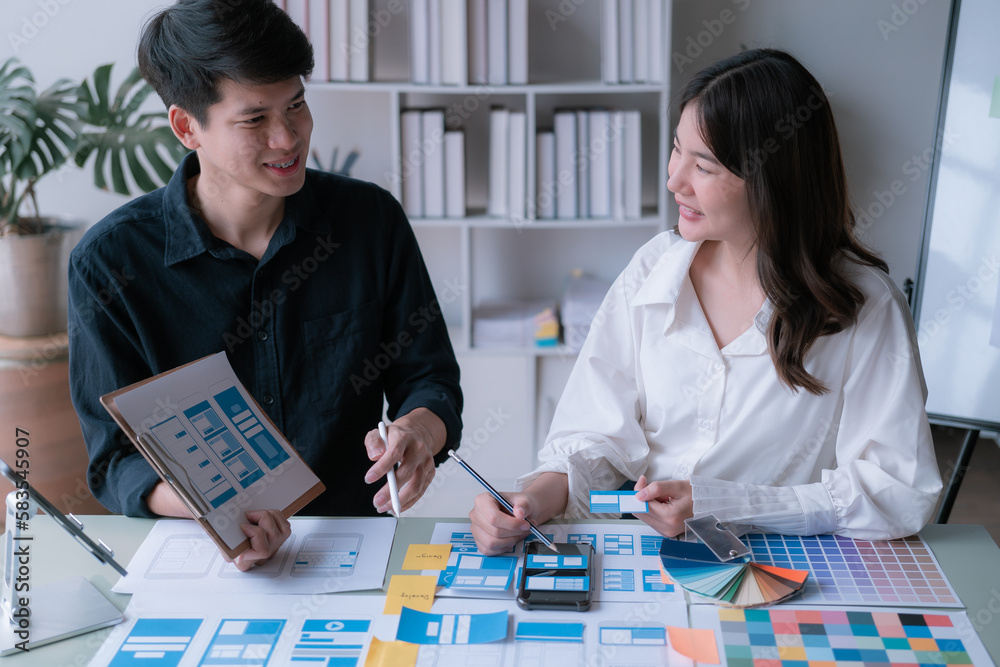 Fototapeta premium Man and woman ecommerce business workers using smartphone and Chart plan at the office.