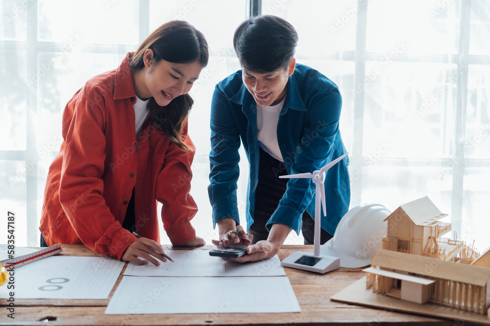 Fototapeta premium Happy young Asian couple enjoying in working time, watching on line chart. Smiling woman Happy.