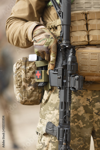 Ukrainian soldier armed with modern 5.56mm .223 assault rifle and equipped with standard pixel camouflage clothing