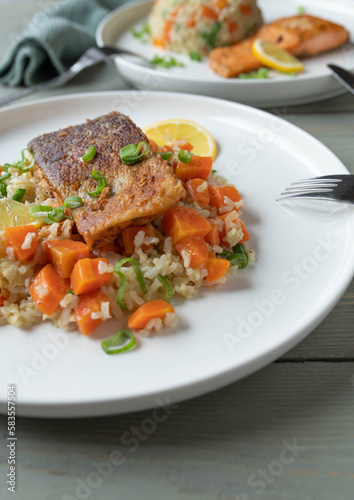 Healthy fish dish with pan fried salmon, brown rice and vegetables.