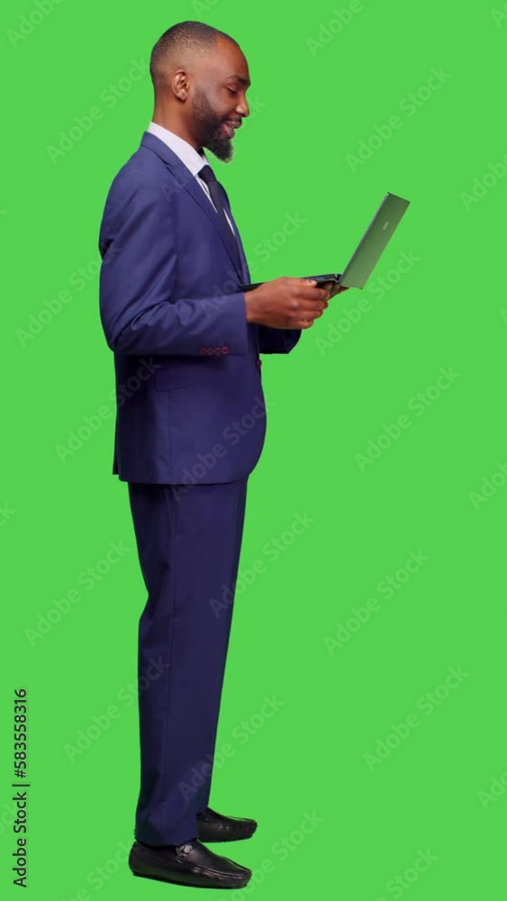 Vertical video: Profile of african american man attending videocall meeting on pc, using laptop to talk on remote teleconference chat. Young business manager in suit talking to people on Vertical video: Profile of african american man attending videocall meeting on pc, using laptop to talk on remote teleconference chat. Young business manager in suit talking to people on