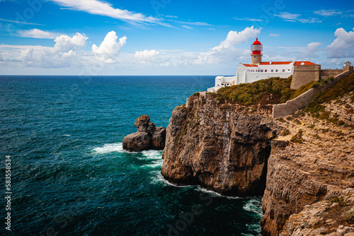 white lighthouse on cliffs at algarve portugal