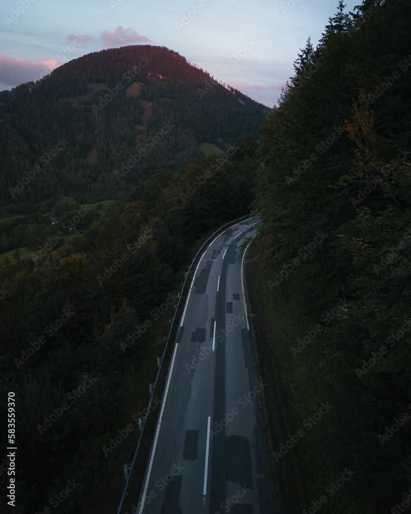 Vertical shot of a small road in the Austrian Alps during sunset