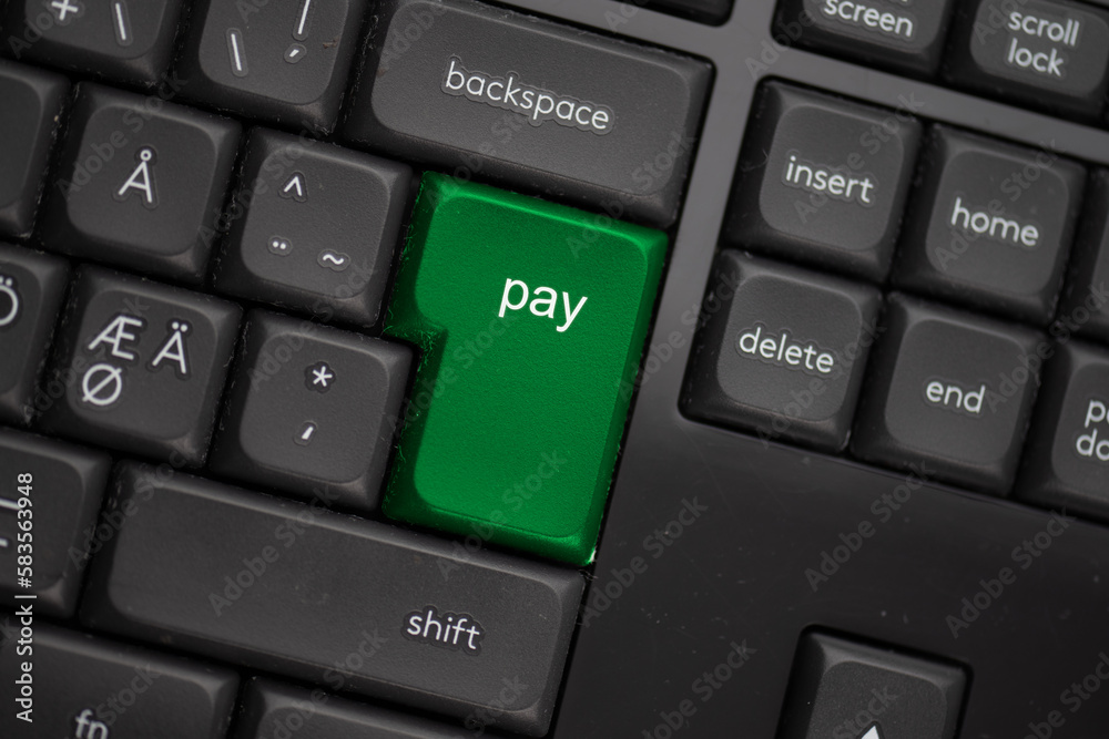 Computer keyboard with a green pay button. Computer keyboard with a green pay button.