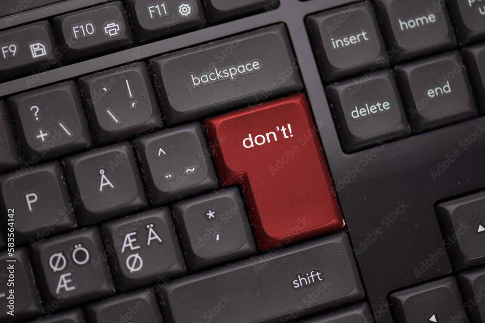 Computer keyboard with a red button saying don’t. Computer keyboard with a red button saying don’t.