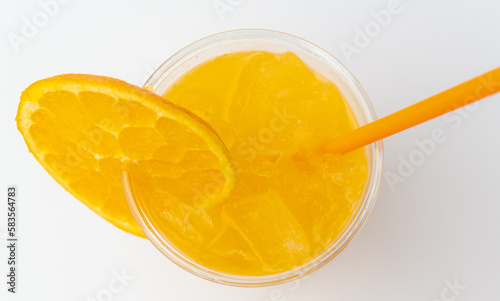 Top view shot of some fresh made orange juice with some ice cubes in glass.