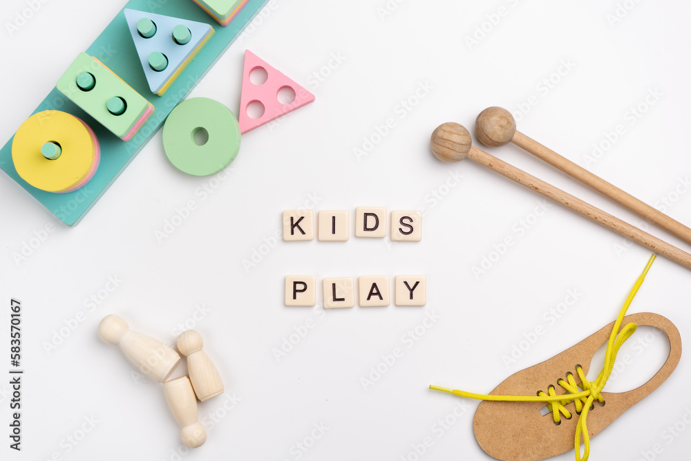 Flat lay of Montessori toys on white background. KIDS PLAY made with tile letters Flat lay of Montessori toys on white background. KIDS PLAY made with tile letters