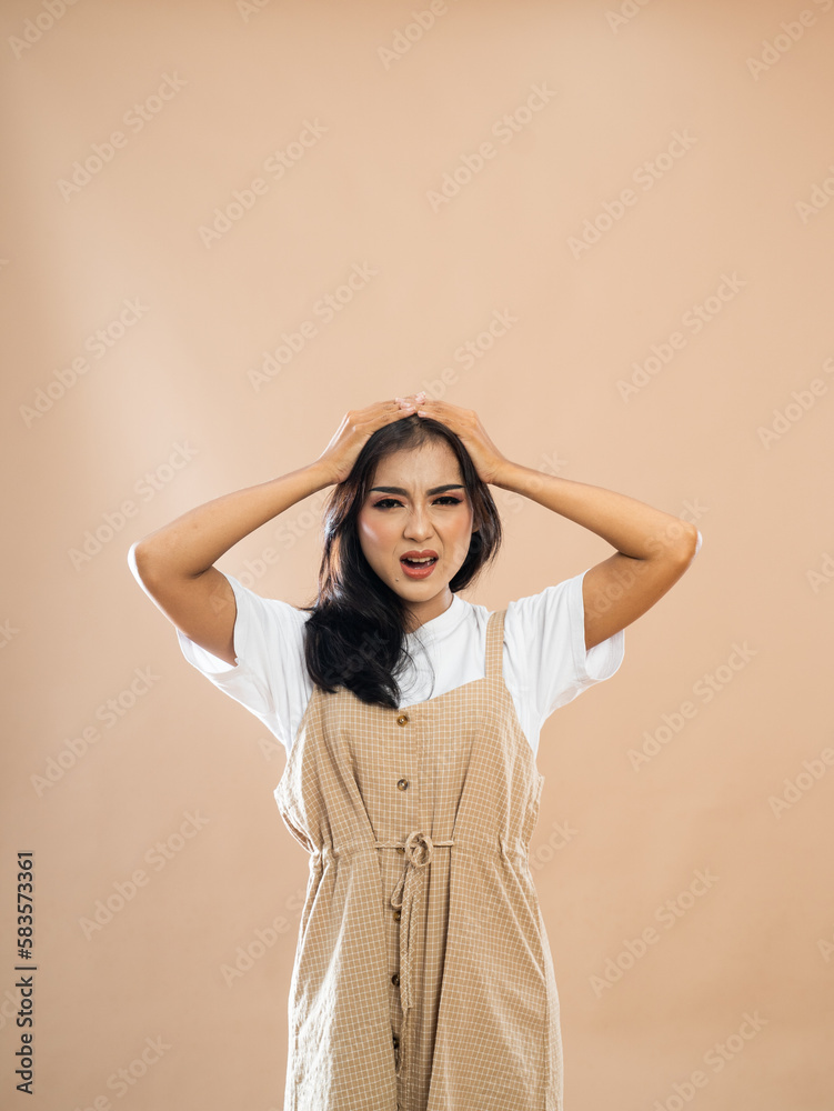 asian woman in casual clothes standing touch her head in pain on isolated background asian woman in casual clothes standing touch her head in pain on isolated background