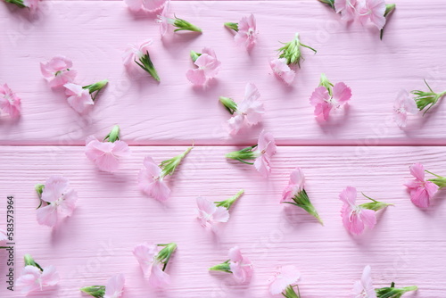 Fototapeta Naklejka Na Ścianę i Meble -  Small pink flowers on wooden table, floral pattern