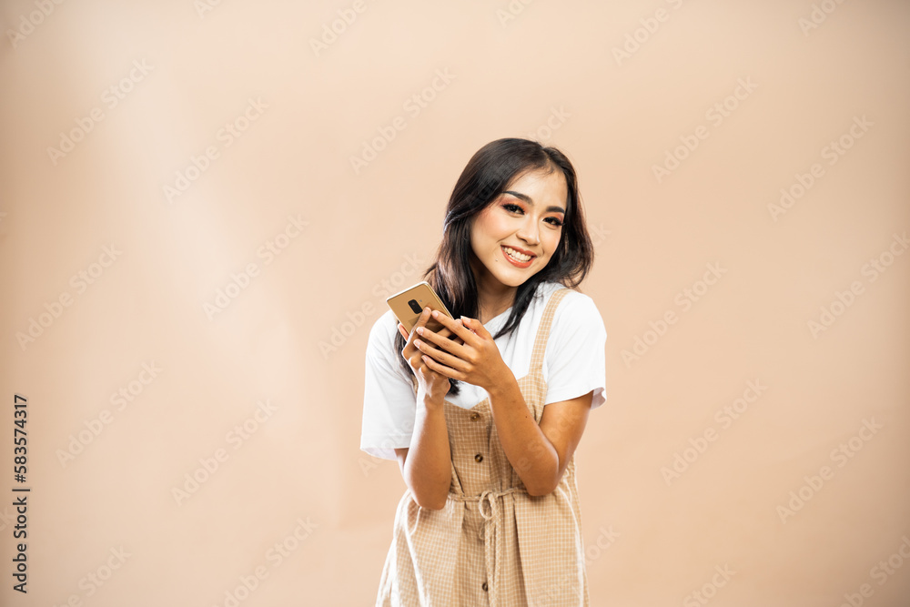 asian woman in casual clothes standing with smile and bring the phone on isolated background asian woman in casual clothes standing with smile and bring the phone on isolated background