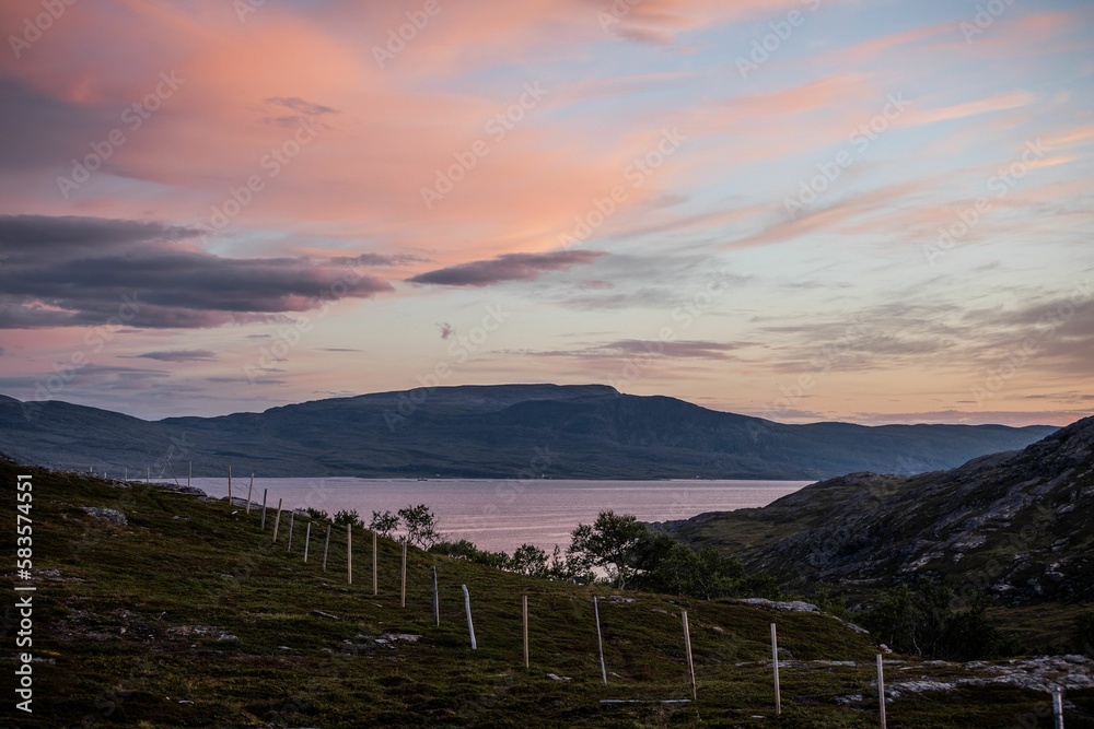 Fototapeta premium Mesmerizing sunrise over the hills and lake in Nothern Norway