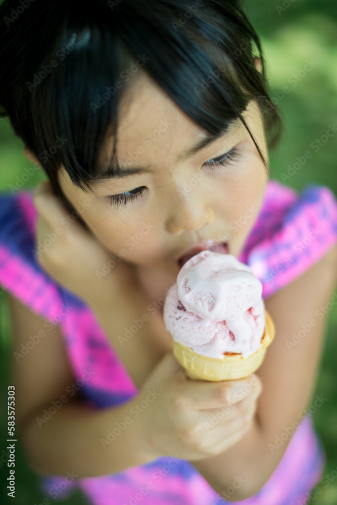 Young asian girl licking strawberry ice cream Young asian girl licking strawberry ice cream