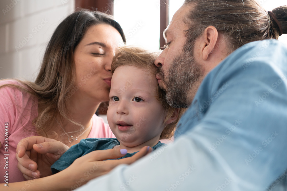 After the little boy wakes up from his nap, his father and mother engage in enjoyable activities in his bedroom. After the little boy wakes up from his nap, his father and mother engage in enjoyable activities in his bedroom.