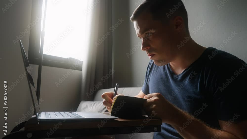 Caucasian male making notes from computer Caucasian male making notes from computer