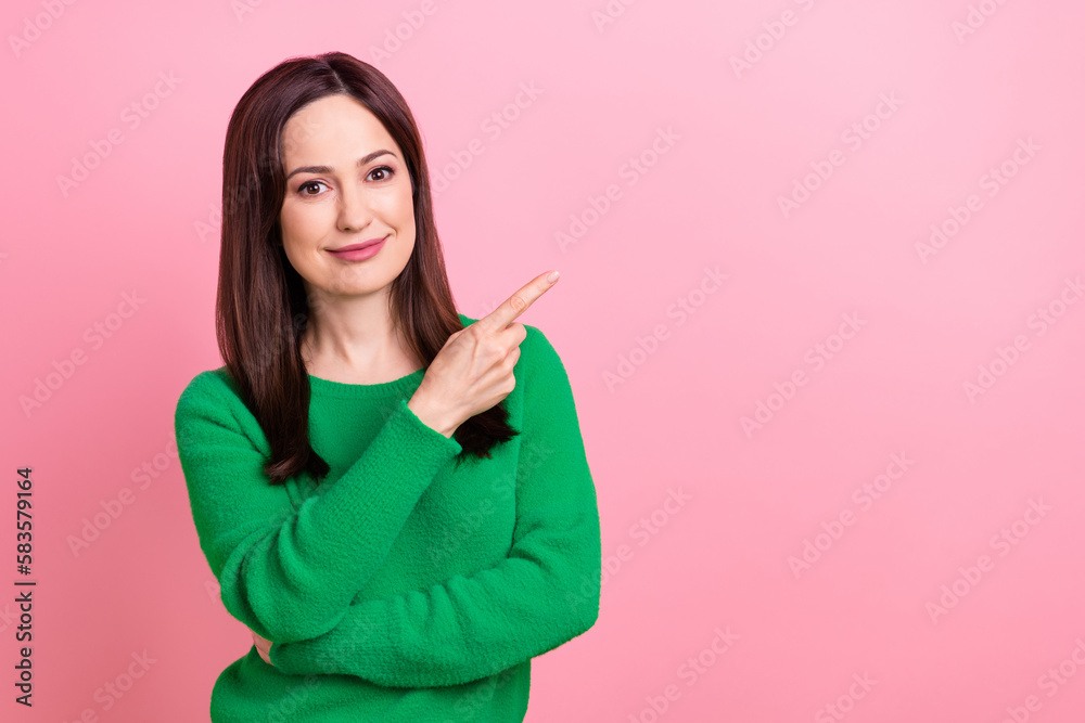 Photo of shiny adorable woman wear green sweater pointing finger empty space isolated pink color background Photo of shiny adorable woman wear green sweater pointing finger empty space isolated pink color background
