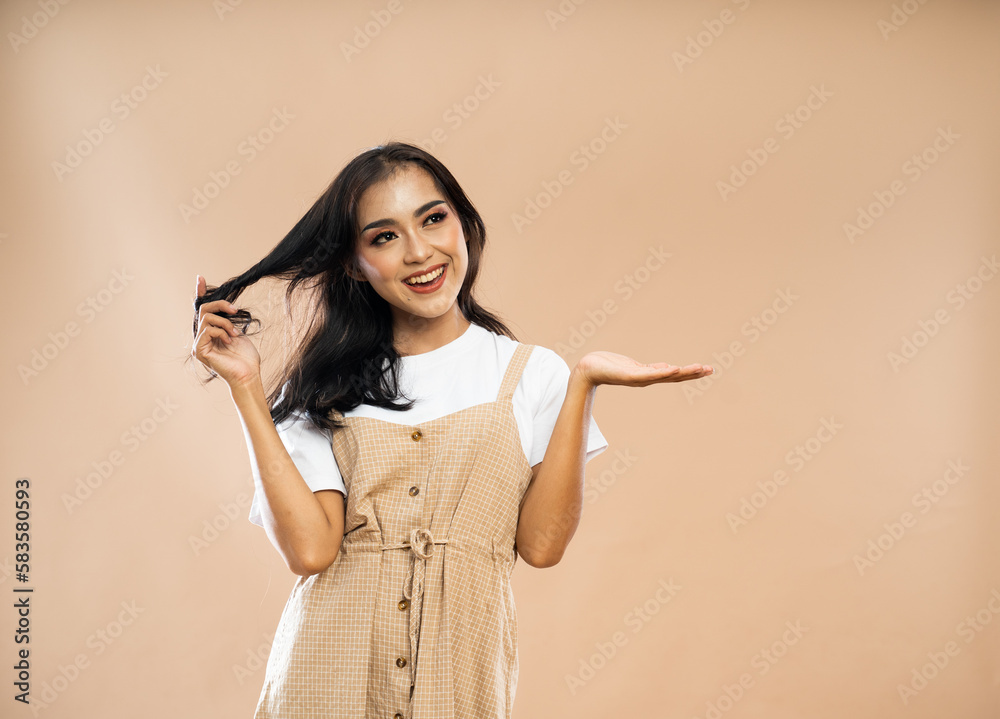 asian woman in casual clothes playing her hair and raising her opened hand on isolated background asian woman in casual clothes playing her hair and raising her opened hand on isolated background
