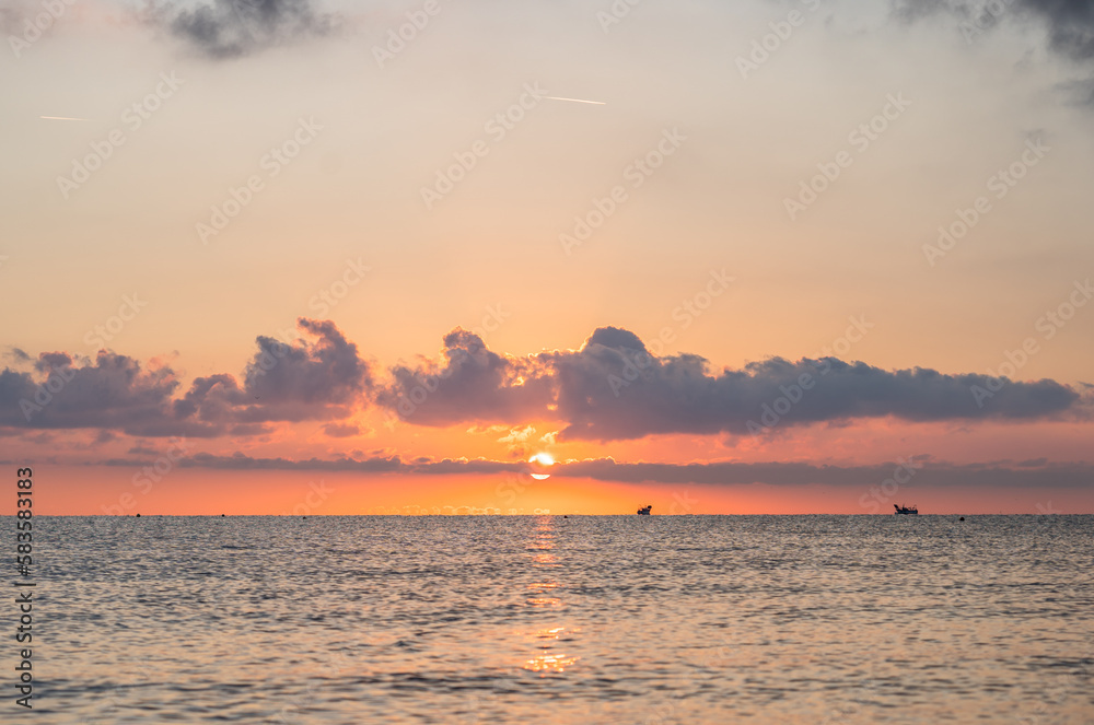 Naklejka premium Sunset on the beach with clouds