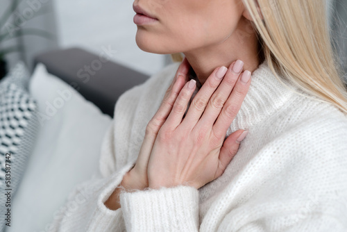 cropped shot of sick woman suffering from throat pain photo