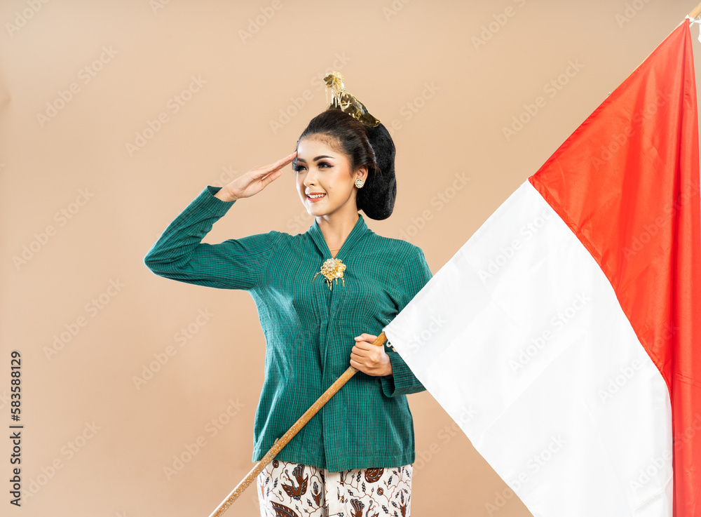 asian woman in green kebaya standing looking right with salutation and holding the indonesian flag on isolated background asian woman in green kebaya standing looking right with salutation and holding the indonesian flag on isolated background
