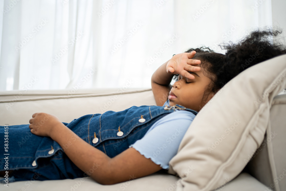 Unpleasant condition. Close up of small pale girl while touching her forehead closed and sleeping. Unpleasant condition. Close up of small pale girl while touching her forehead closed and sleeping.